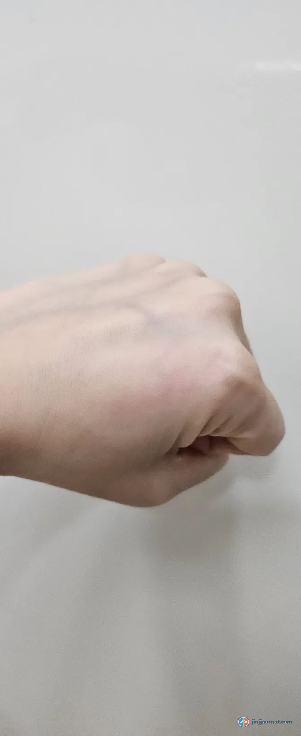 The same hand after cleansing, with the eyeliner gone and a faint pink stain remaining
