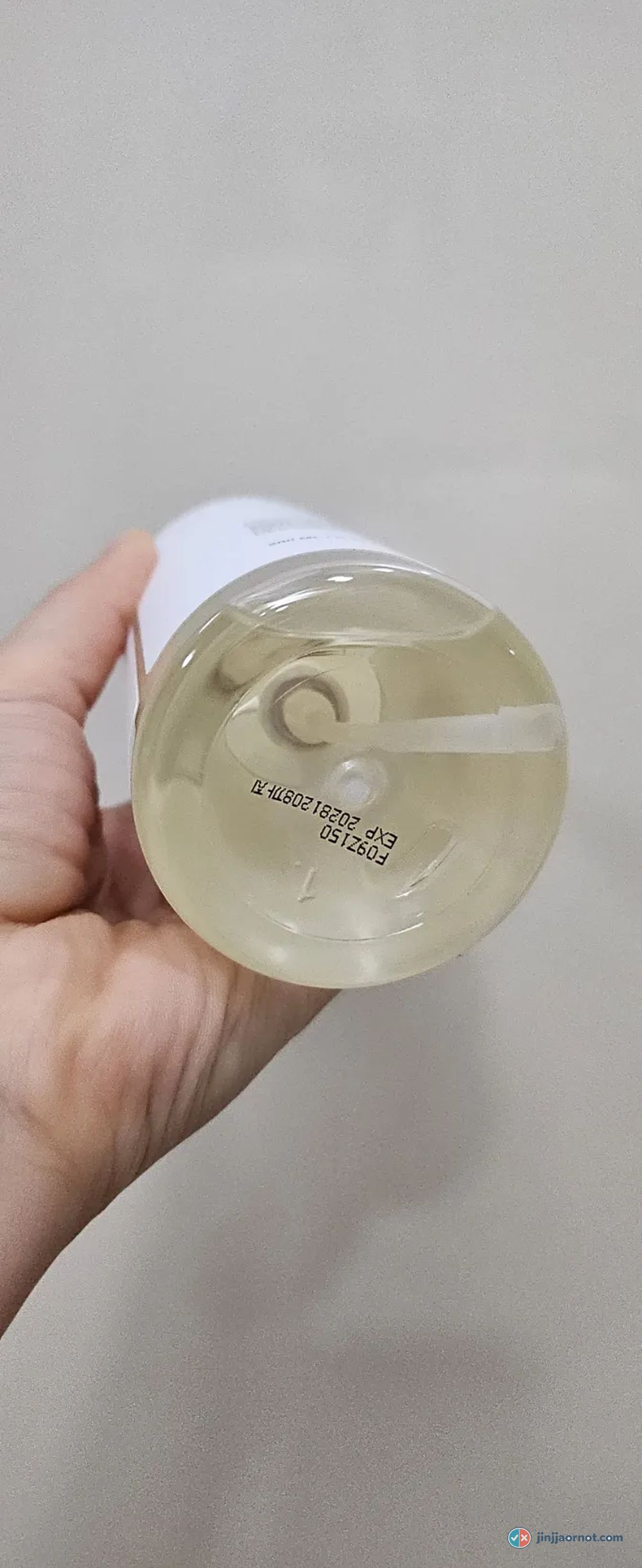 Anua cleansing oil poured out, showing a pale yellow, very fluid texture