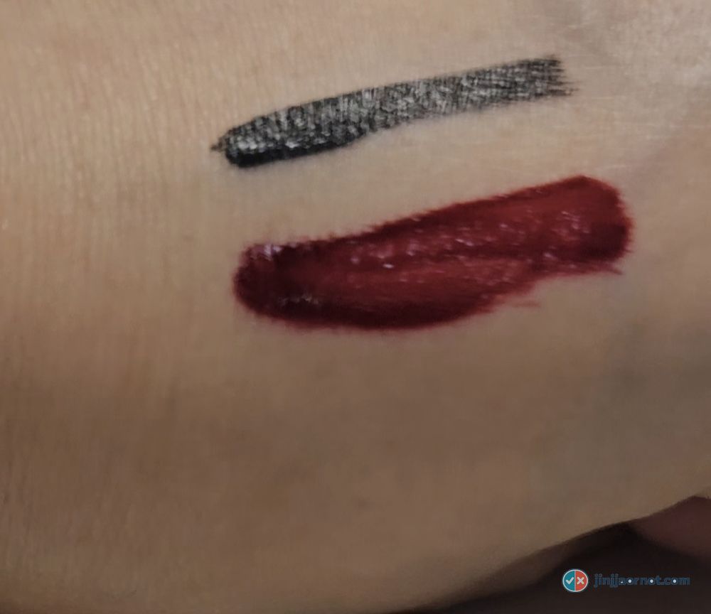 Liquid eyeliner line and deep red lip tint swatch on the back of a hand before cleansing