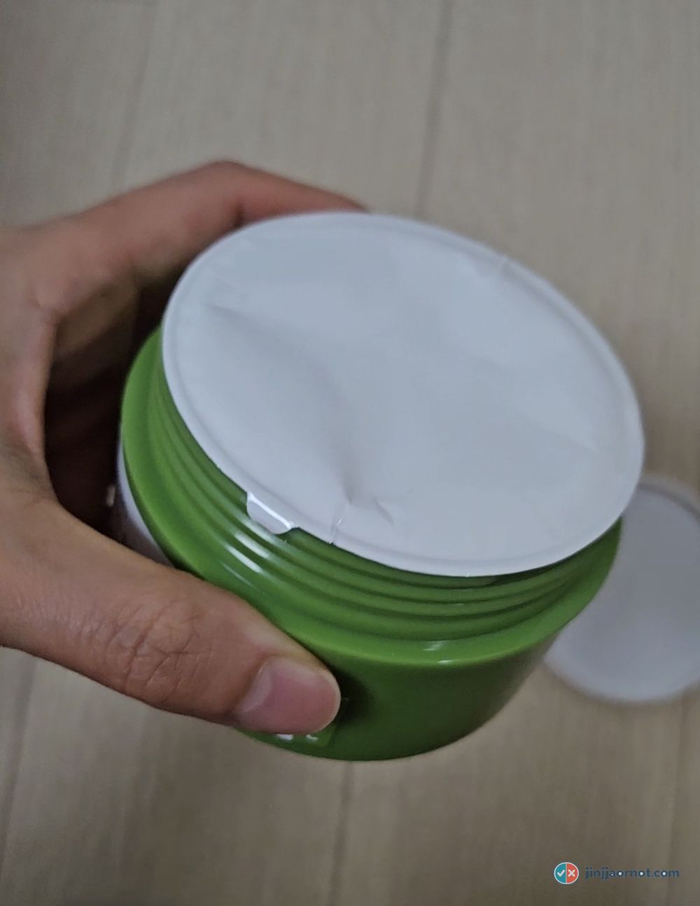 The white inner cover disc sitting on top of the beplain balm inside the jar
