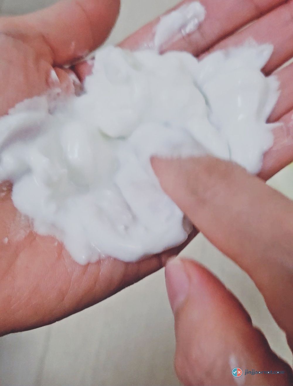 The same balm melted into a milky liquid across the fingers, without any water added
