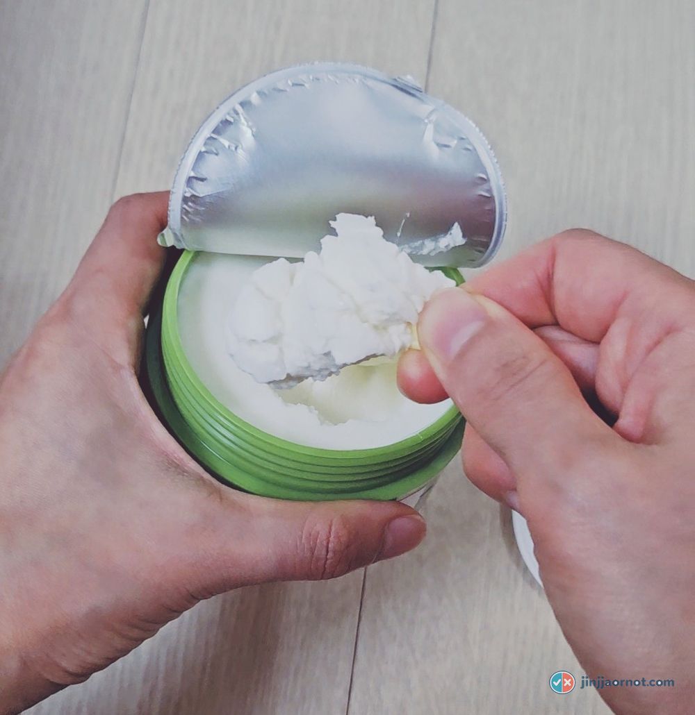 A spatula lifting a soft scoop of the white milk balm out of the jar