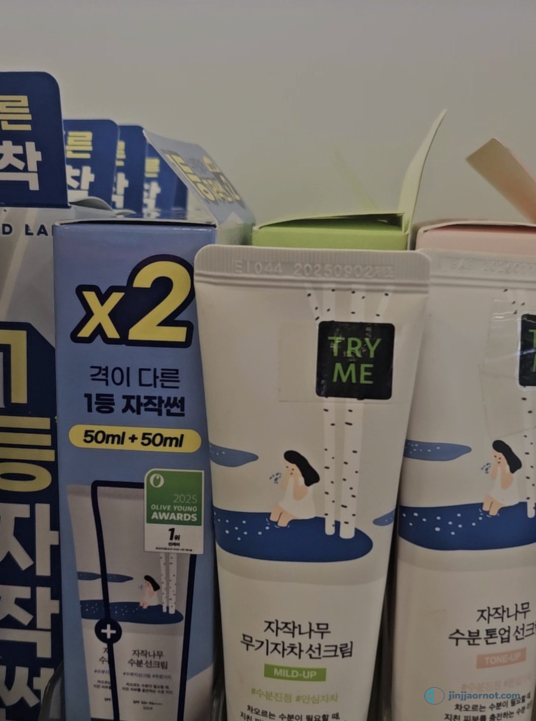 Round Lab birch sunscreens side by side on a Korean store shelf: the moisturizing sunscreen, the Mild-Up mineral version, and the tone-up version