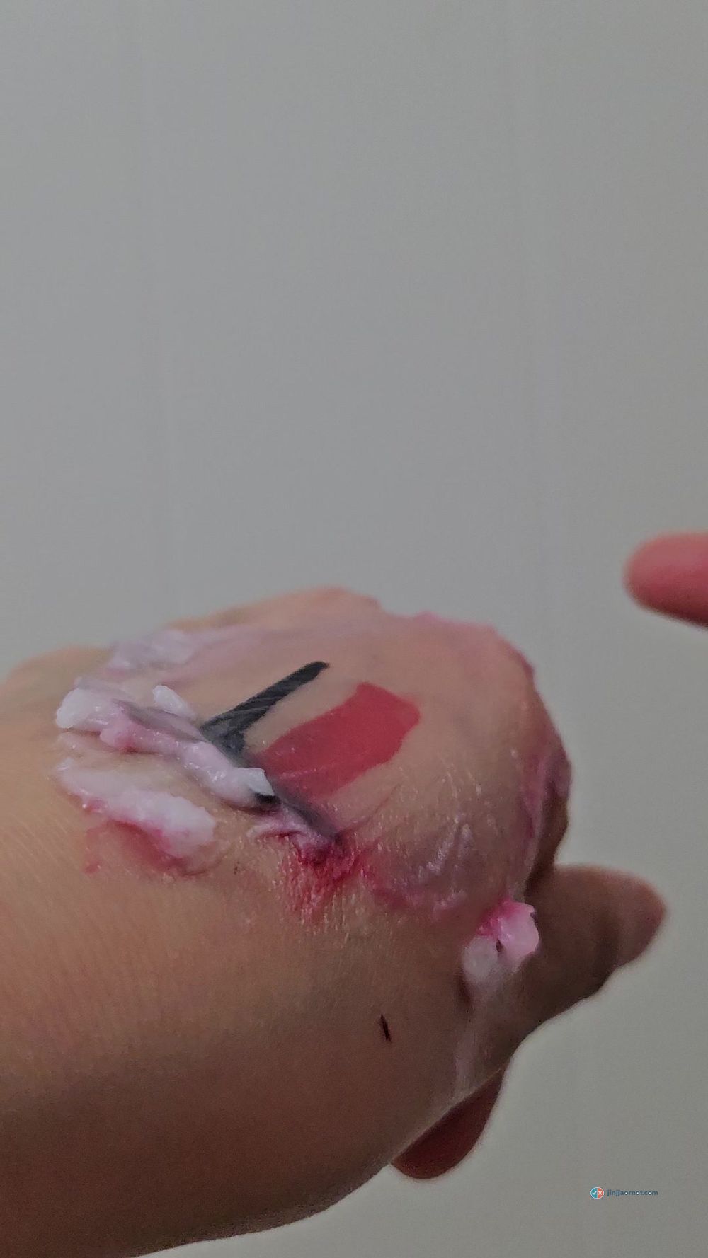 Beauty of Joseon cleansing balm breaking down lip tint and eyeliner on the back of a hand