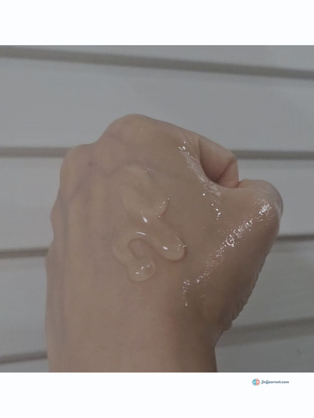 Beauty of Joseon Glow Serum being dispensed onto the back of a hand from the glass dropper