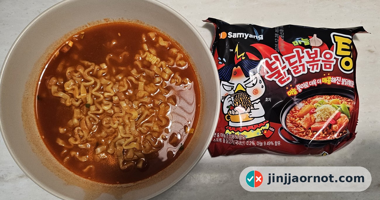 A bowl of cooked Buldak Tang spicy soup ramen next to its red Samyang package