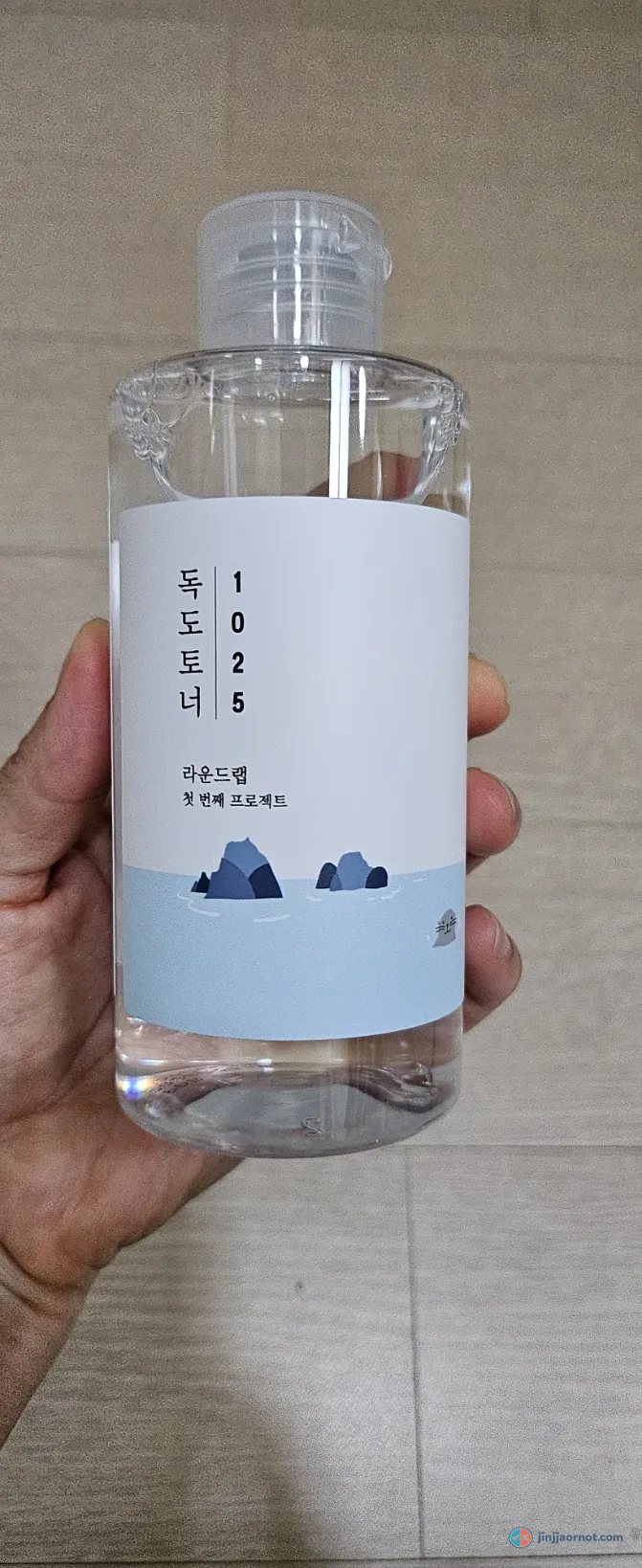 A bottle of Round Lab 1025 Dokdo Toner with its blue island label, held in hand