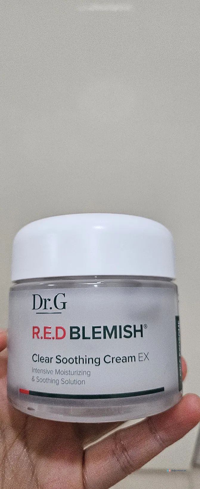 Dr.G R.E.D Blemish Clear Soothing Cream EX jar held in a hand in Korea