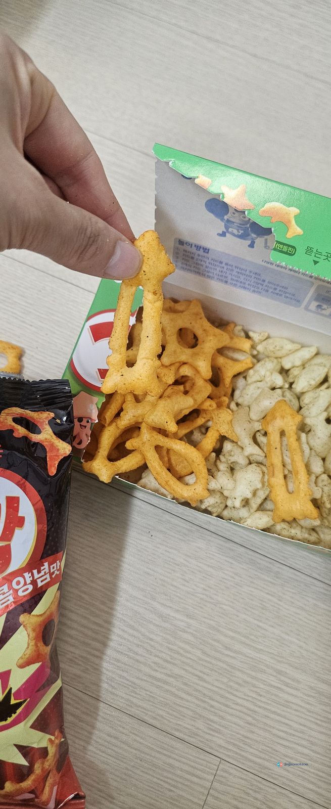 Orange Hot Goraebap crackers next to the paler regular Goraebap crackers, poured into the same box