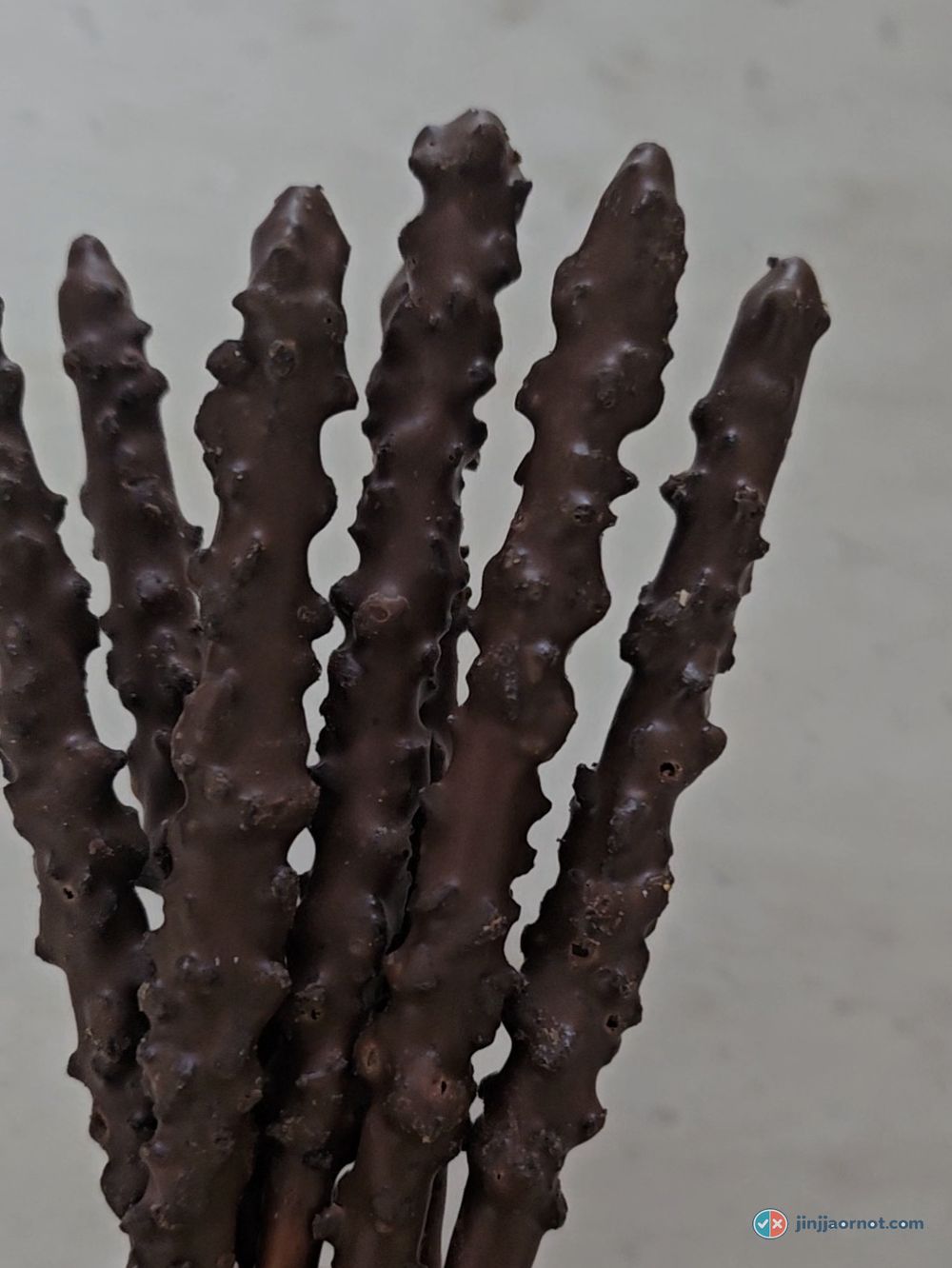 Almond Pepero sticks close up, chocolate coating covered in visible almond pieces