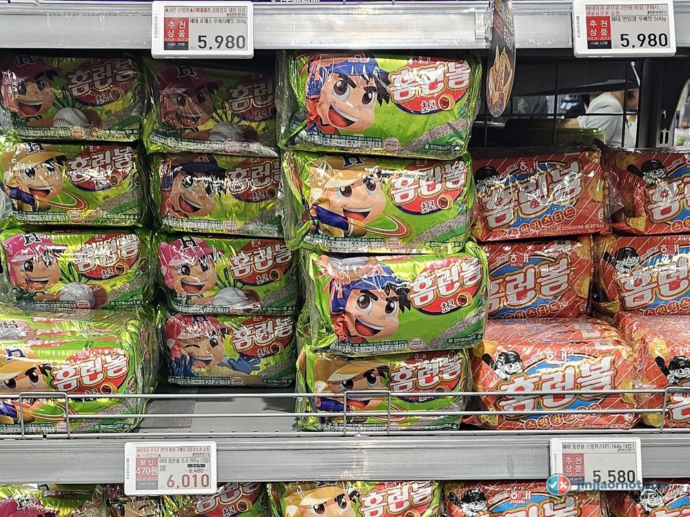Shrimp Crackers and Yukpokkang jerky snack held up in a Korean supermarket