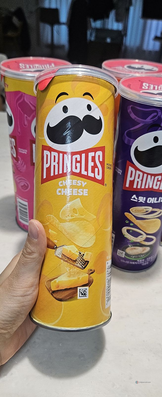 A pink can of Pringles Butter Caramel with Korean lettering, sweet and salty combo