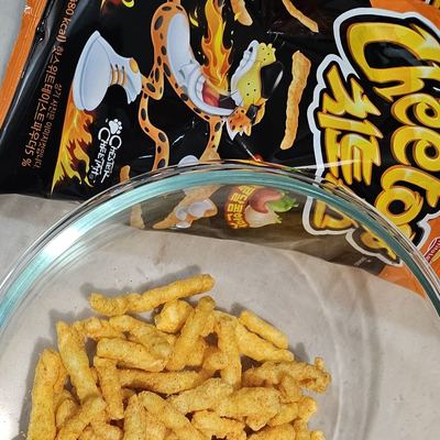 Korean Cheetos bag with a bowl of the puffs poured out